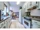 Traditional kitchen with white cabinets, tile floor, and adjacent breakfast nook at 1633 Kiawah Ct, Gastonia, NC 28056