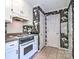 Kitchen featuring white cabinets, tile floors, and floral wallpaper at 1633 Kiawah Ct, Gastonia, NC 28056