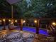 Evening view of backyard featuring a lit pool, string lights, modern deck, and comfortable seating area at 1673 Beleek Ridge Ln, Clover, SC 29710