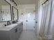 Modern bathroom featuring dual vanity, shower, and gray cabinets at 1673 Beleek Ridge Ln, Clover, SC 29710
