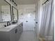 Clean bathroom features double vanity, shower with curtain, and updated fixtures in a well-lit space at 1673 Beleek Ridge Ln, Clover, SC 29710