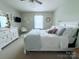 A spacious bedroom with a comfortable white bed, a dresser, and soft natural light from the window at 1673 Beleek Ridge Ln, Clover, SC 29710