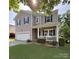 Charming two-story home featuring a covered front porch, manicured lawn, and attached two car garage at 1673 Beleek Ridge Ln, Clover, SC 29710