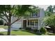 Charming two-story home with a welcoming front porch, well-maintained lawn, and mature trees at 1673 Beleek Ridge Ln, Clover, SC 29710