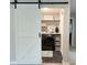 Stylish laundry room with a modern sliding barn door, featuring chic decor and efficient appliances at 1673 Beleek Ridge Ln, Clover, SC 29710
