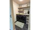 Tastefully designed laundry room featuring modern black appliances, hexagon tile flooring, and open shelving at 1673 Beleek Ridge Ln, Clover, SC 29710