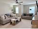 Cozy living room with plush sofas, a wooden coffee table, and large windows for ample natural light at 1673 Beleek Ridge Ln, Clover, SC 29710