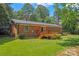 Back of the brick home with wooden deck and grassy lawn at 1713 Andover Nw St, Concord, NC 28027