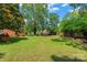 Expansive backyard featuring lush green lawn, mature trees, and a wooden deck, perfect for outdoor entertaining at 1713 Andover Nw St, Concord, NC 28027