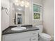Bathroom vanity with white sink, black counter, and window providing natural light at 1713 Andover Nw St, Concord, NC 28027