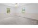 Spacious carpeted bedroom featuring two large windows and a ceiling fan at 1713 Andover Nw St, Concord, NC 28027