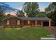 Charming one-story brick home featuring a well-manicured lawn, black shutters, and an attached single-car garage at 1713 Andover Nw St, Concord, NC 28027