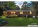 Back exterior of the brick home with wooden deck and grassy lawn, enhanced with virtual staging at 1713 Andover Nw St, Concord, NC 28027