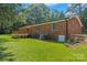 Back exterior of the brick home with wooden deck and grassy lawn at 1713 Andover Nw St, Concord, NC 28027
