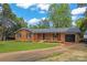 Charming one-story brick home featuring a well-manicured lawn, black shutters, and an attached single-car garage at 1713 Andover Nw St, Concord, NC 28027