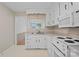 Traditional-style kitchen features white cabinetry, matching appliances, and a window above the sink at 1713 Andover Nw St, Concord, NC 28027