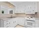 The kitchen features white cabinets, appliances, and a built-in microwave at 1713 Andover Nw St, Concord, NC 28027