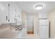 The kitchen features white cabinets and appliances with a view to a second room at 1713 Andover Nw St, Concord, NC 28027