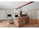 Inviting living room with hardwood floors, a white brick fireplace, ceiling fan, and bookshelf storage at 1713 Andover Nw St, Concord, NC 28027