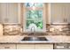 Well-lit kitchen with stainless steel sink, neutral countertops and backsplash, and a window offering a view to the backyard at 2019 Steeplechase Dr, Rock Hill, SC 29732