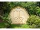 Backyard storage shed with double doors nestled among mature trees and lush greenery at 2019 Steeplechase Dr, Rock Hill, SC 29732