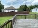 Exterior backyard featuring a wooden deck and fenced perimeter at 210 Rhyne St, Stanley, NC 28164
