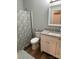 This cozy bathroom boasts unique wood floors, patterned shower curtain, and granite countertops at 210 Rhyne St, Stanley, NC 28164