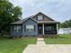 Inviting blue home featuring a cozy covered porch, showcasing curb appeal at 210 Rhyne St, Stanley, NC 28164