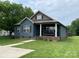 Charming blue home with a covered front porch and well-manicured lawn at 210 Rhyne St, Stanley, NC 28164