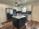 Bright kitchen features a center island, stainless steel appliances, white cabinetry, and tiled backsplash at 210 Rhyne St, Stanley, NC 28164