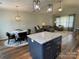 Open concept living area boasts a dining space, living room with couches, and a kitchen island at 210 Rhyne St, Stanley, NC 28164