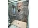 Glass enclosed shower features attractive gray tile, a built in niche, and a hand held shower head at 210 Rhyne St, Stanley, NC 28164