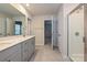 Bright bathroom with a double vanity, quartz countertop, tiled floor, and glass-enclosed shower at 2143 Rolling Hills Ct, Stanley, NC 28164