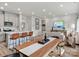 Open concept living and dining area with modern furniture, a kitchen island with bar stools, and a dining table at 2143 Rolling Hills Ct, Stanley, NC 28164