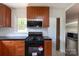 Well-lit kitchen featuring wood cabinets, black countertops, stainless steel appliances, and tiled backsplash at 2628 Clydesdale Ter, Charlotte, NC 28208