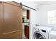 Well-lit laundry room featuring a sliding door, modern washer and dryer, and convenient access to other areas of the home at 2628 Clydesdale Ter, Charlotte, NC 28208