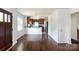 Open-concept living room with hardwood floors and a view into the adjacent kitchen with black countertops at 2628 Clydesdale Ter, Charlotte, NC 28208