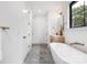 Bathroom features a soaking tub, modern fixtures, and a gray tile floor for a serene ambiance at 3903 Plainview Rd, Charlotte, NC 28208