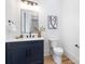 Chic powder room features a blue vanity, quartz countertop, modern fixtures, and stylish accent wall at 3903 Plainview Rd, Charlotte, NC 28208