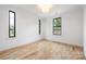 Bright bedroom with hardwood floors, three windows and white trim for a clean, modern aesthetic at 3903 Plainview Rd, Charlotte, NC 28208