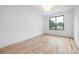 Bright and airy bedroom with hardwood floors and a large window offering neighborhood views at 3903 Plainview Rd, Charlotte, NC 28208
