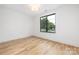 Bright and airy bedroom with hardwood floors and a large window offering neighborhood views at 3903 Plainview Rd, Charlotte, NC 28208