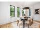 Elegant dining room with modern chandelier, black table, and chairs, bathed in natural light from large windows at 3903 Plainview Rd, Charlotte, NC 28208