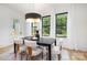 Bright dining area featuring a dark table, four chairs, large windows with white curtains, and stylish decor at 3903 Plainview Rd, Charlotte, NC 28208