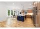 Bright, open kitchen and dining area featuring custom cabinets, stainless appliances, and a large island with seating at 3903 Plainview Rd, Charlotte, NC 28208