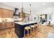 Open-concept kitchen with a blue island, seating, stainless appliances, and adjacent living and dining spaces at 3903 Plainview Rd, Charlotte, NC 28208