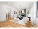Bright living room with a fireplace, hardwood floors, white sofas, and a staircase in the background at 3903 Plainview Rd, Charlotte, NC 28208