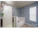 Bright bathroom features a glass-enclosed shower, soaking tub, and neutral tile flooring at 4003 Fine Robe Dr, Indian Trail, NC 28079