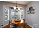 Bright dining area with a rustic wooden table, chandelier, and corner windows, perfect for gatherings at 4003 Fine Robe Dr, Indian Trail, NC 28079