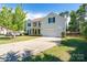 Traditional home with a manicured lawn, long driveway, and black shutters against a light yellow facade at 4003 Fine Robe Dr, Indian Trail, NC 28079